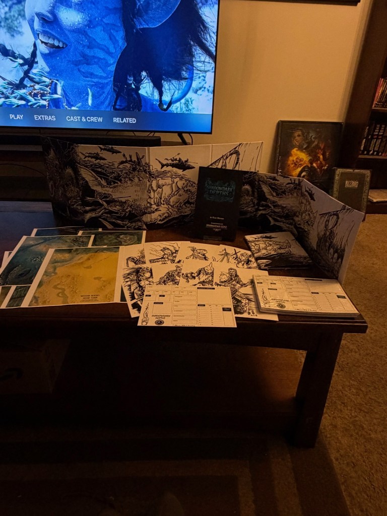 A tabletop RPG setup featuring character sheets, maps, and a rulebook for a game called 'Shadowdark: Depths' on a coffee table, with a TV displaying a scene from a movie in the background.