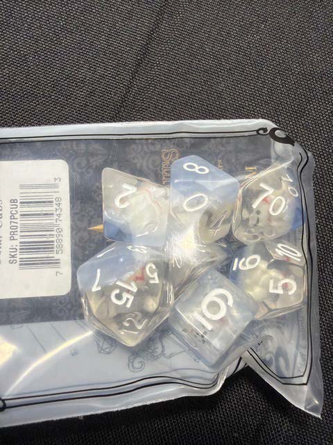 A bag containing six translucent polyhedral dice with numbers visible on each face.
