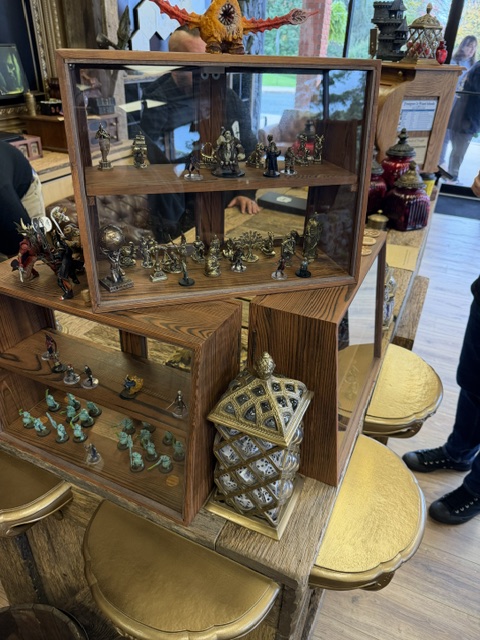 Display case featuring various figurines and collectibles, including a decorative lantern, set in a retail space.
