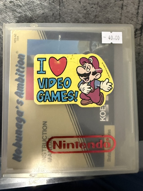 A sticker featuring Mario from Nintendo with the text 'I ❤️ VIDEO GAMES!' on a video game case for Nebuchadnezzar's Ambition, priced at $40.00.